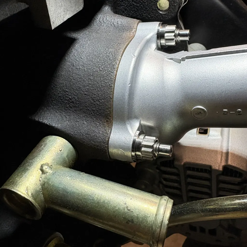 RB26 thermostat housing neck secured to block with full titanium stud kit including three studs, washers, and nuts