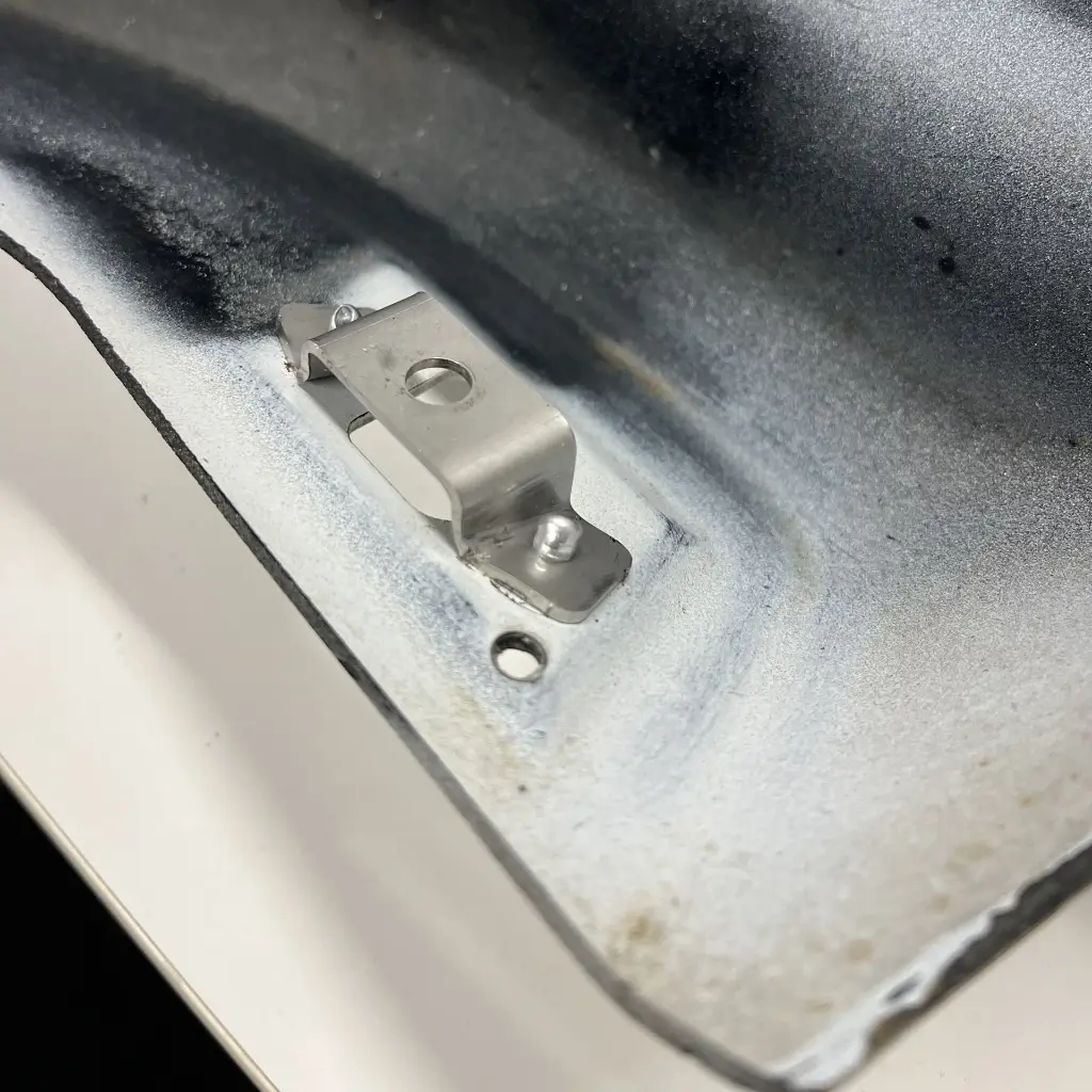 Physical Nissan Skyline R33 GT-R Spat bodykit part with the folded stainless steel bracket fitted.